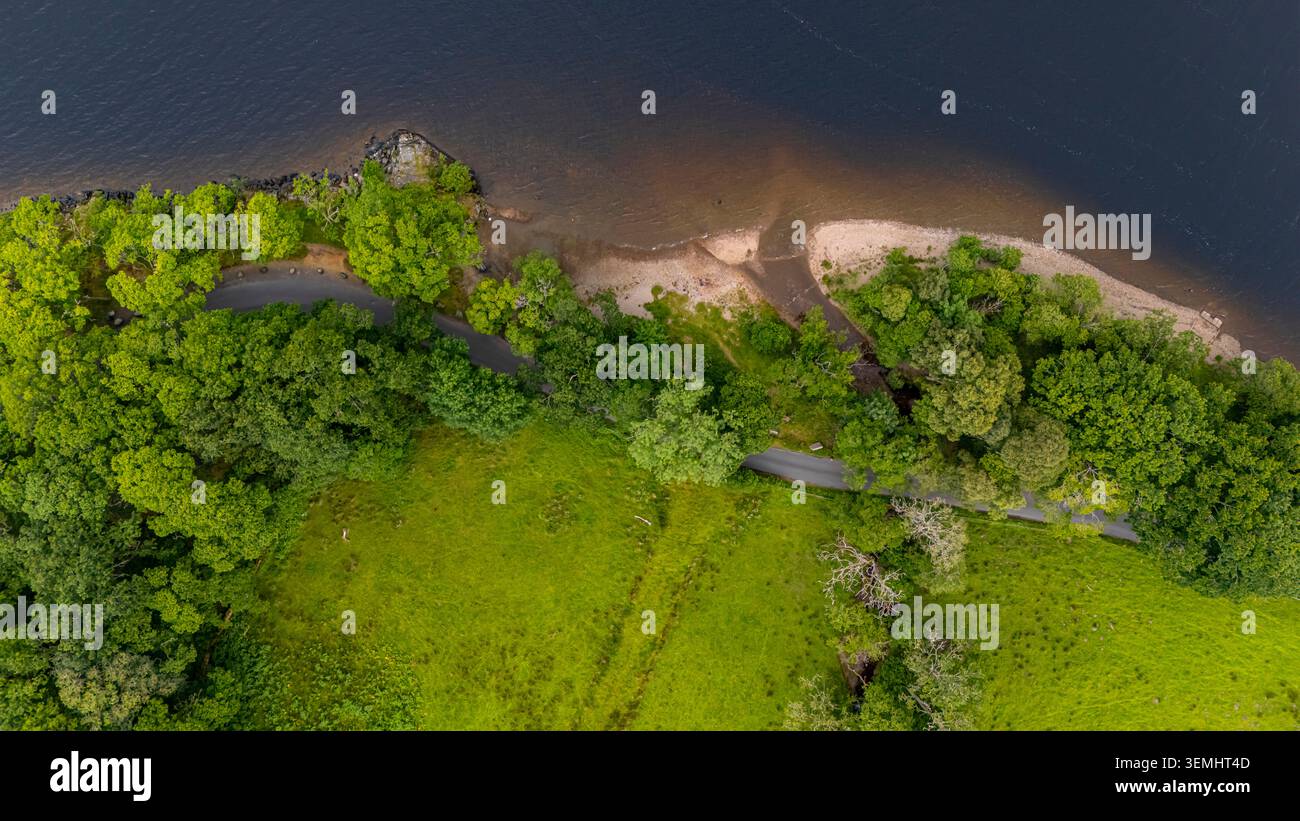 Vista a volo d'uccello del litorale lungo Loch Earn, con vegetazione lussureggiante, insenature sabbiose e acque calme del lago. Foto Stock