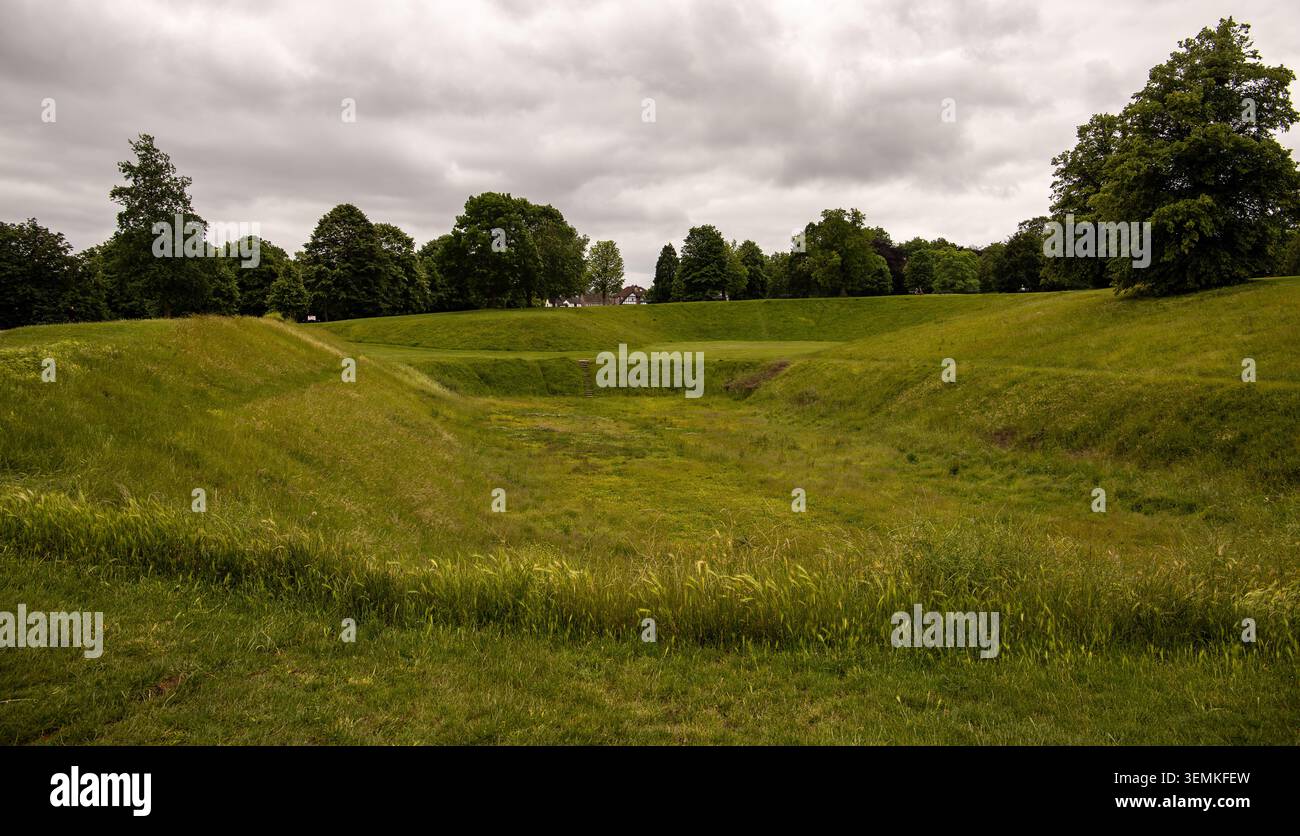 Un campo erboso con un paesaggio concavo sommerso circondato da alberi verdi maturi sotto un suggestivo cielo nuvoloso Carshalton Sutton Foto Stock