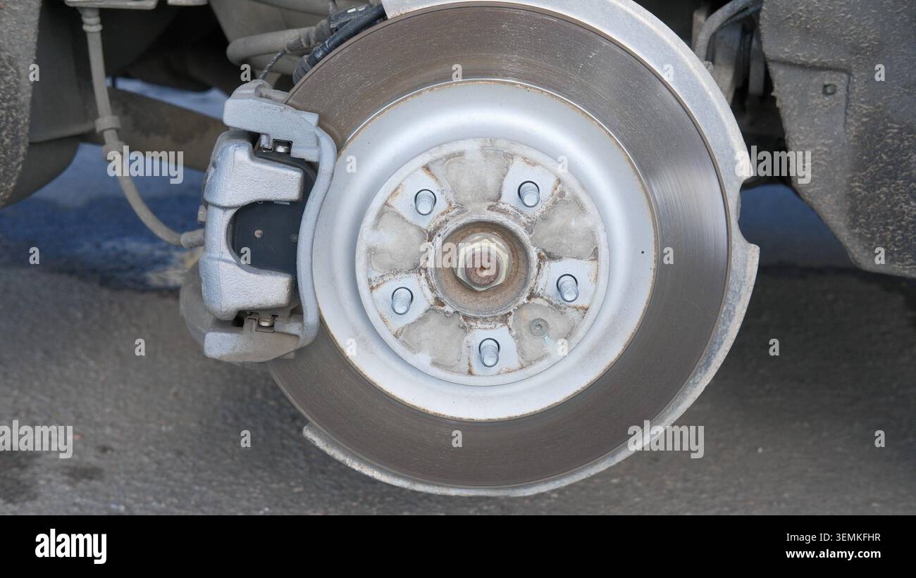 Complessivo freno a disco sul veicolo. Manutenzione vettura, punto sostituzione pneumatici. Dettagli del sistema di rotazione delle ruote. Officina di riparazione e centro di assistenza. Sicurezza Foto Stock