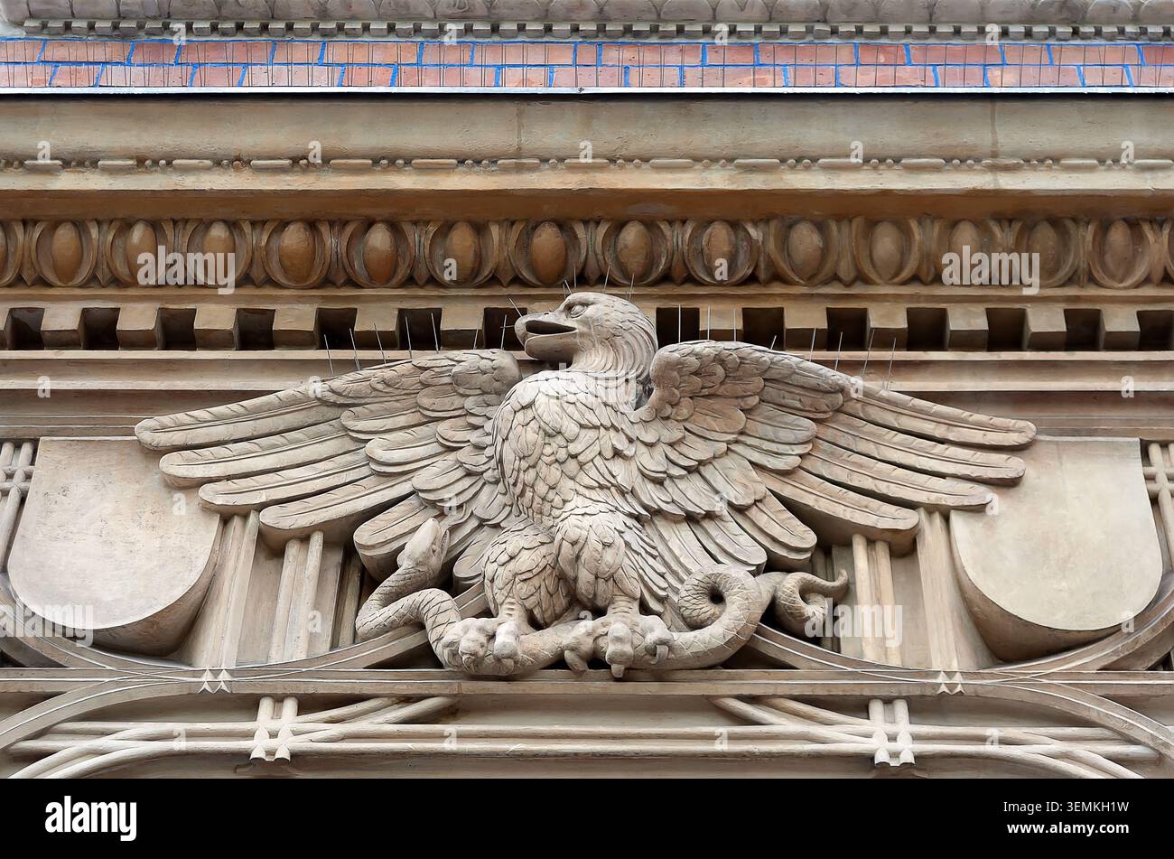 Dettaglio architettonico dell'aquila che divora un serpente sulla facciata dell'edificio in Polonia Foto Stock