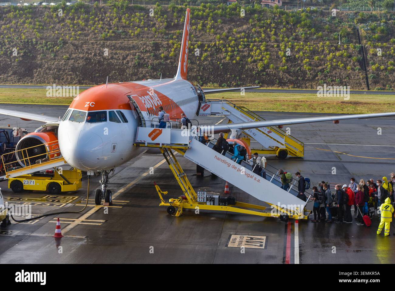 I passeggeri che salgono su un aereo Airbus A320 easyJet tramite le scale mobili Portway sull'asfalto dell'aeroporto di Madeira, Funchal, Portogallo. Foto Stock