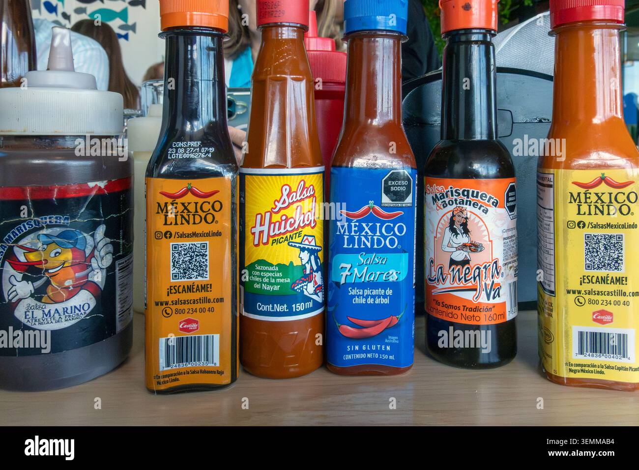 Bottiglie e condimenti con salsa calda messicana sul tavolo del ristorante in Messico Foto Stock