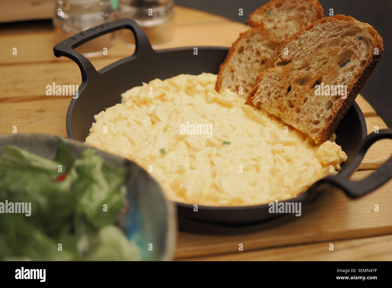 Piatto per colazione con uova e pane in un ambiente da caffetteria Foto Stock
