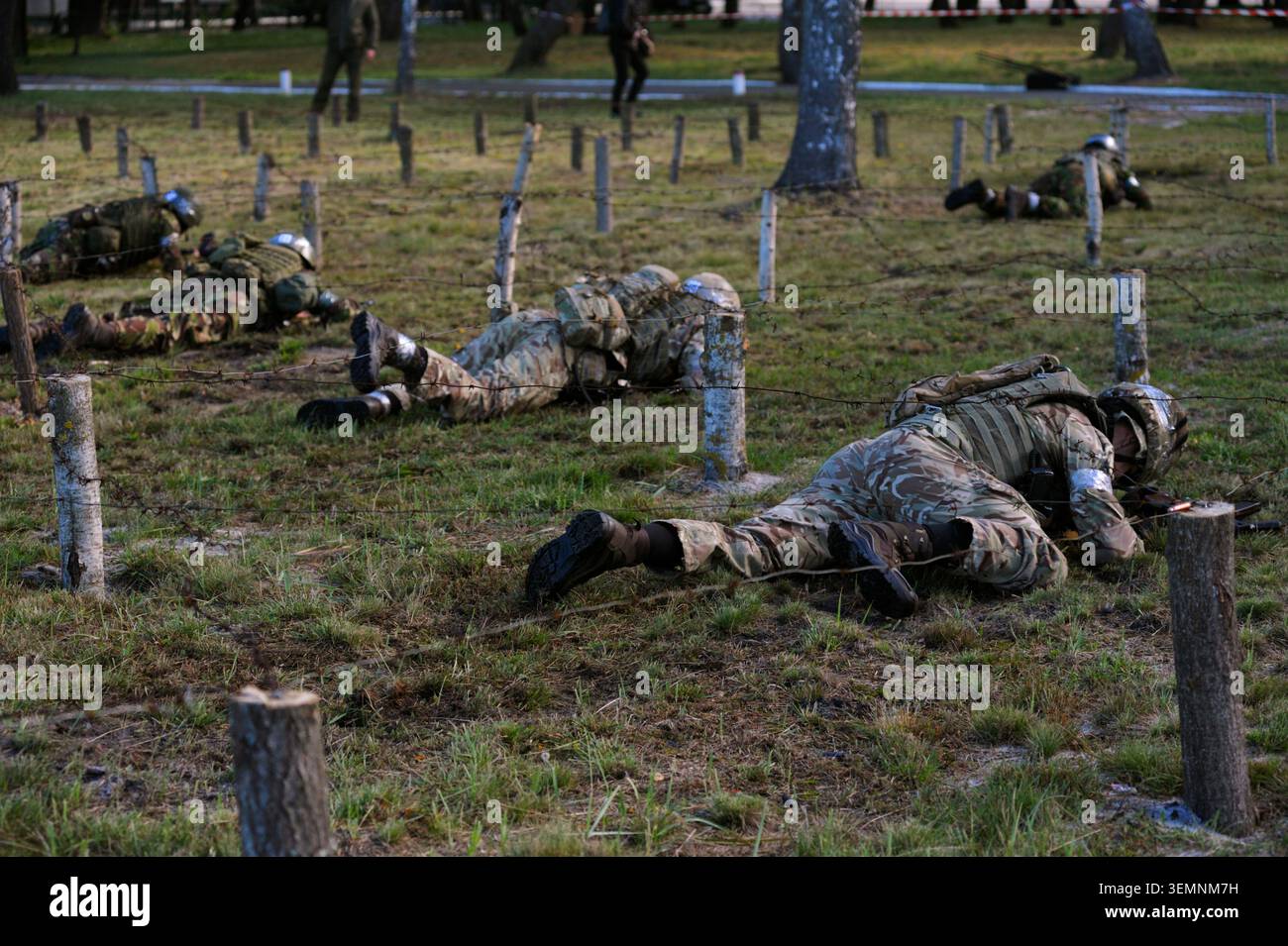 Soldati ucraini che strisciano sotto filo spinato durante un addestramento militare intensivo al campo di pratica. Foto Stock