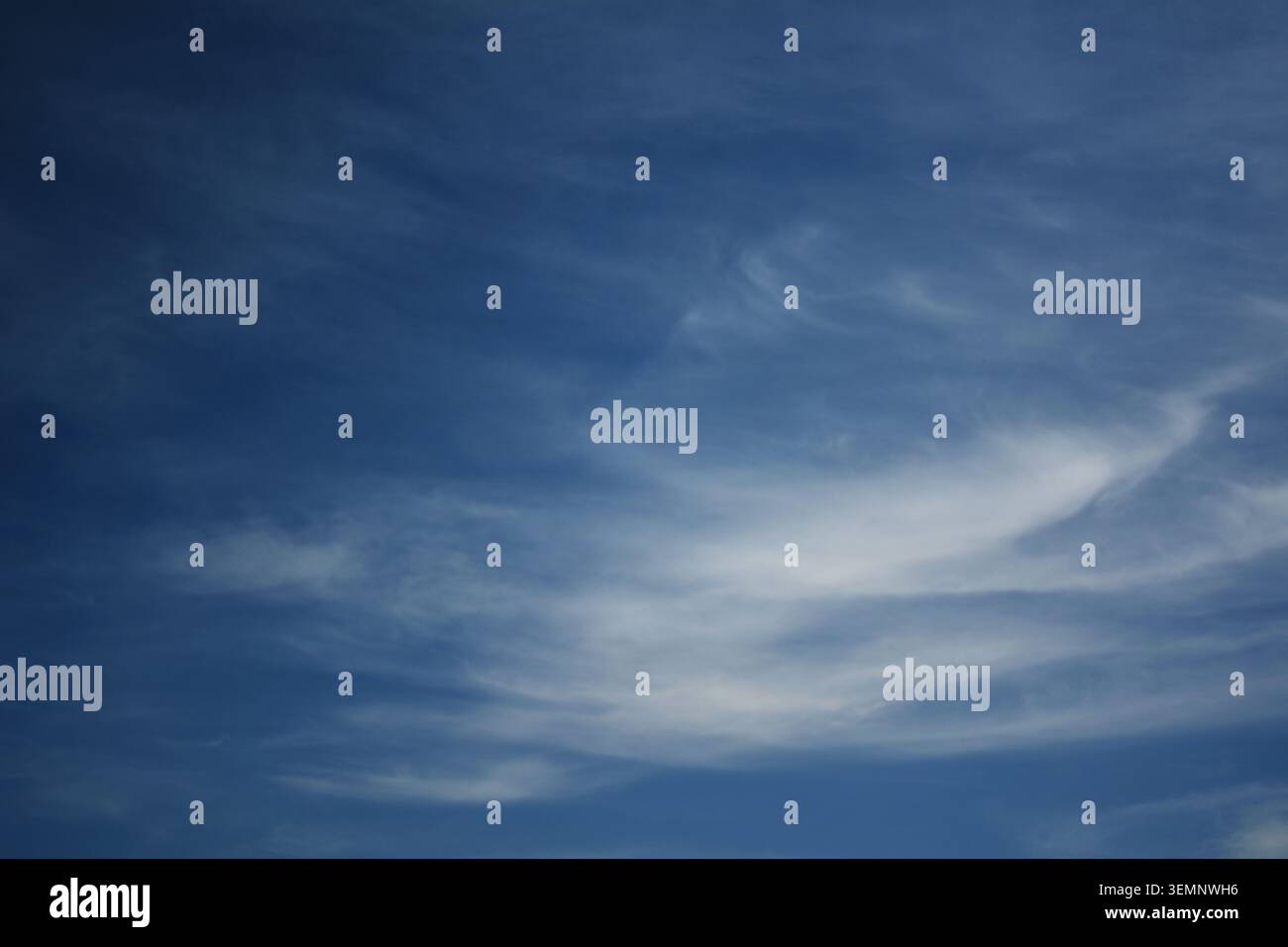 Le nuvole bianche si estendono attraverso un cielo azzurro limpido con luce soffusa, creando un'atmosfera serena e tranquilla nell'ampia e priva di ostacoli natura Foto Stock
