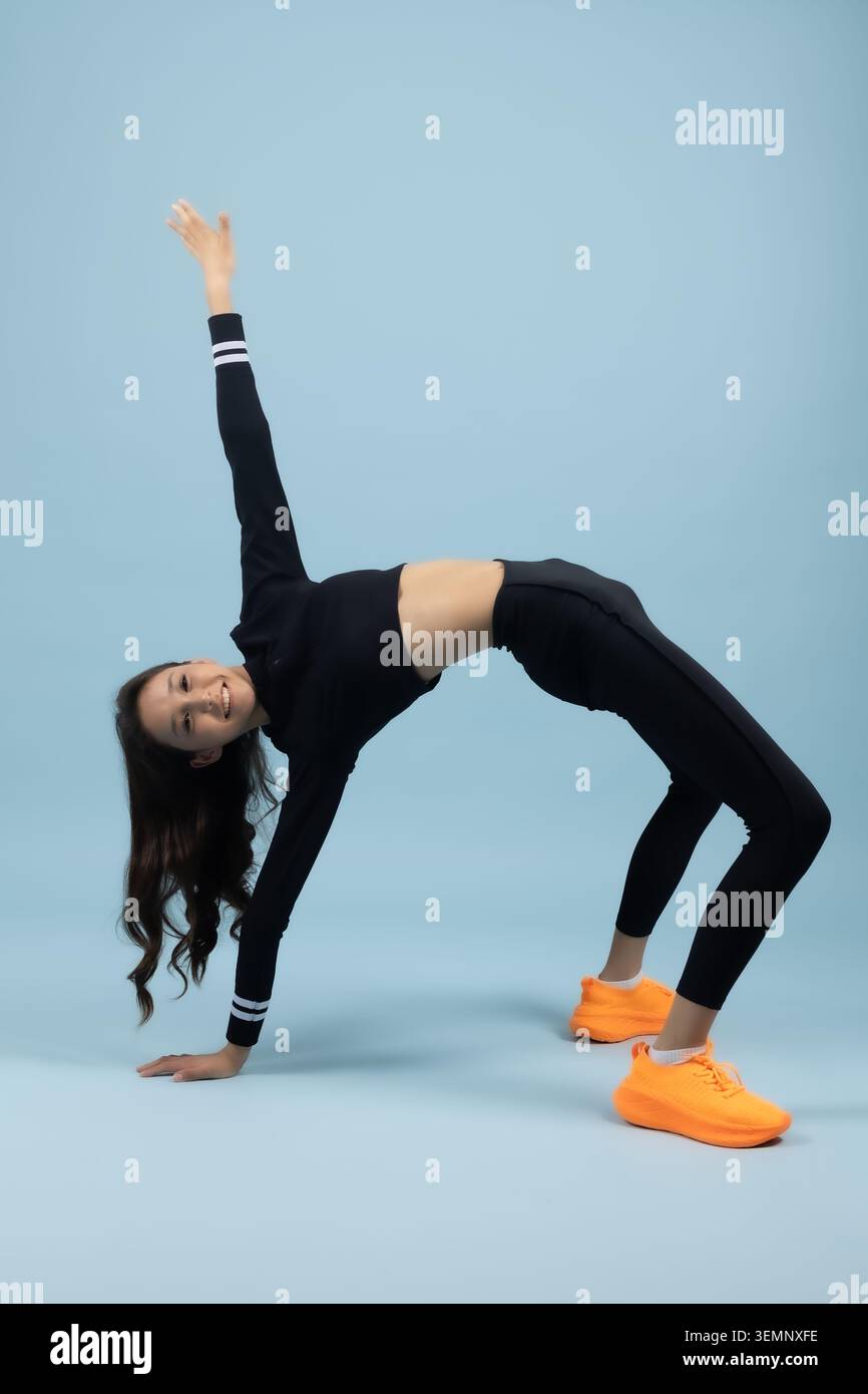 Giovane donna flessibile che esegue un esercizio acrobatico sul ponte posteriore Foto Stock