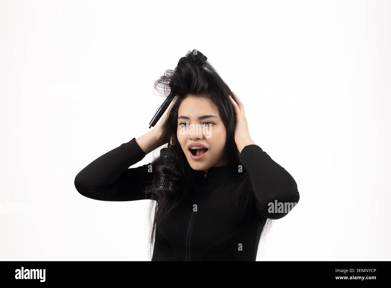 Una giovane donna stressata che si tira i capelli disordinati con mal di testa Foto Stock
