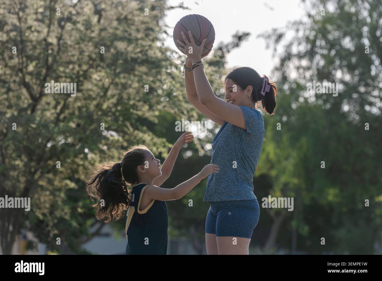 Madre e figlia giocano a basket all'aperto Foto Stock