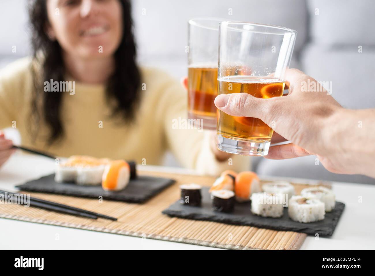 Primo piano di un paio di bicchieri durante un pasto sushi a casa. Ristorante informale e concetto di stile di vita sociale che propone cucina giapponese, relax, tog Foto Stock