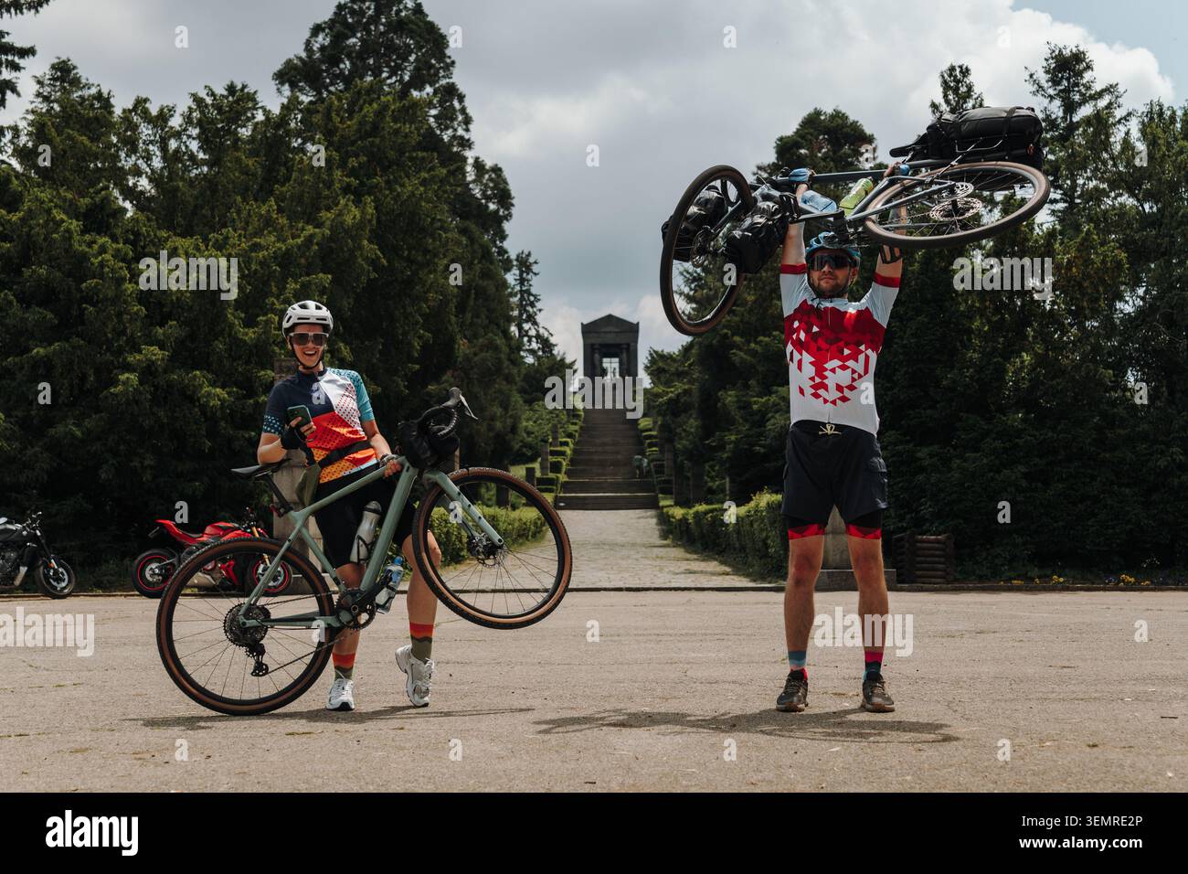 Due ciclisti sollevano le loro biciclette dopo una corsa impegnativa. Ciclo di resistenza e concetto di realizzazione. Foto Stock