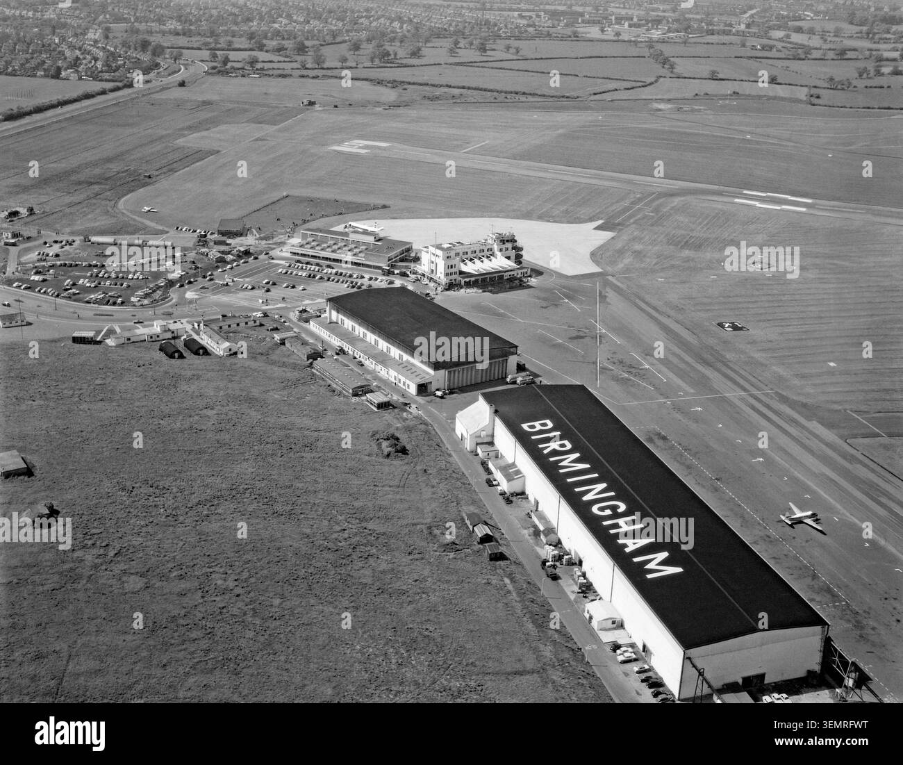 Vista aerea dell'aeroporto di Birmingham, West Midlands, Inghilterra, Regno Unito nei primi anni '1960 I lavori per l'aeroporto di Birmingham a Elmdon non sono iniziati fino alla fine degli anni '1930, e ha aperto nel 1939. L'elegante terminal art deco, con le sue enormi tettoie a strapiombo, è visibile qui al centro. Nel 1961 fu costruito un terminal internazionale (qui a sinistra del terminal originale). Nel 1970 l'aeroporto di Birmingham gestiva circa un milione di passeggeri all'anno. Foto Stock