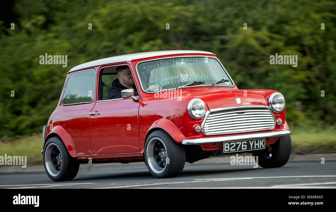 Stony Stratford, Bucks, Regno Unito - 7 giugno 2026: 1985 Rover Mini auto rossa che guida su una strada britannica Foto Stock
