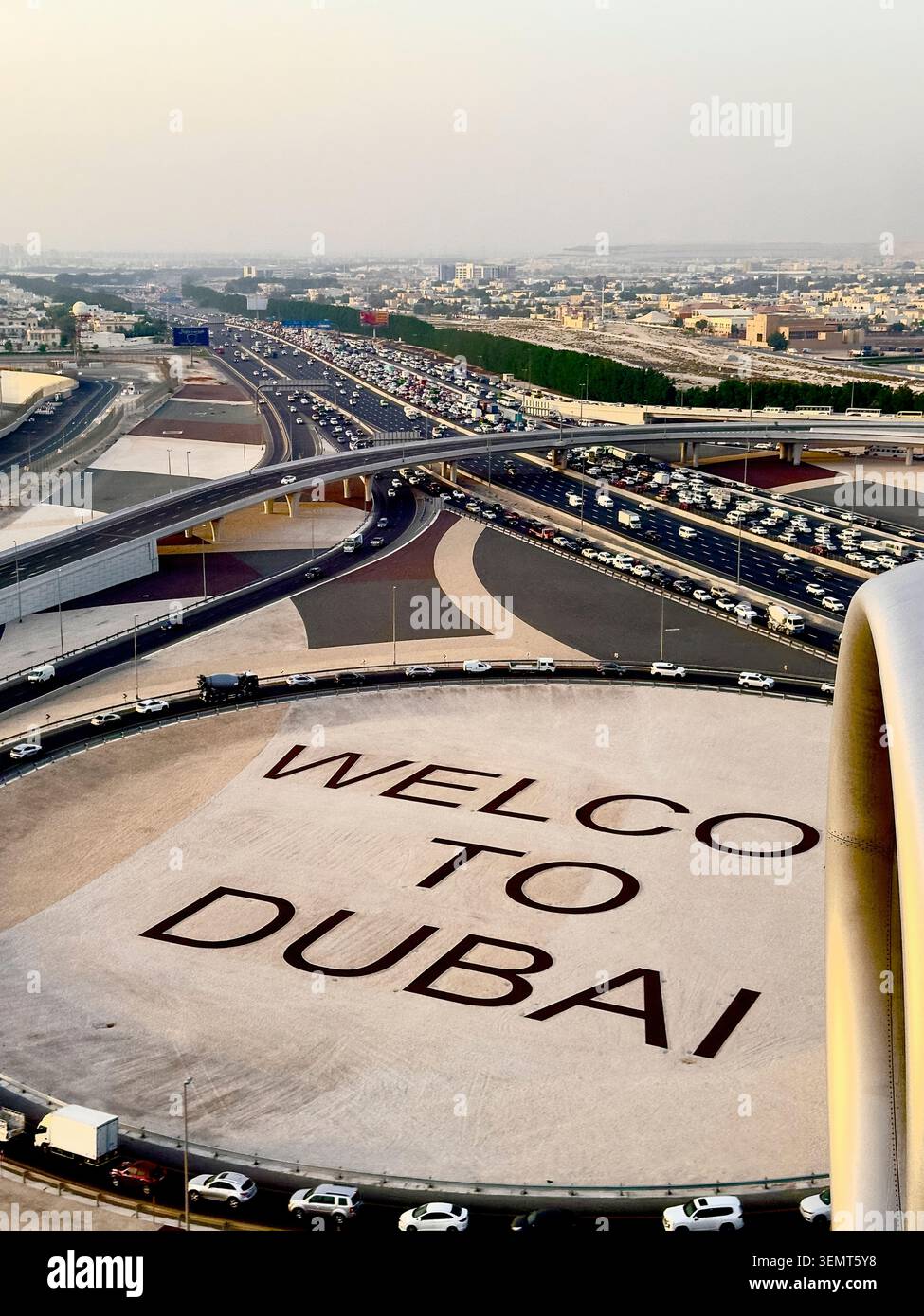 L'iconico cartello Welcome to Dubai si affaccia su un massiccio interscambio stradale congestionato vicino all'Aeroporto Internazionale di Dubai, con un forte traffico sottostante. Foto Stock