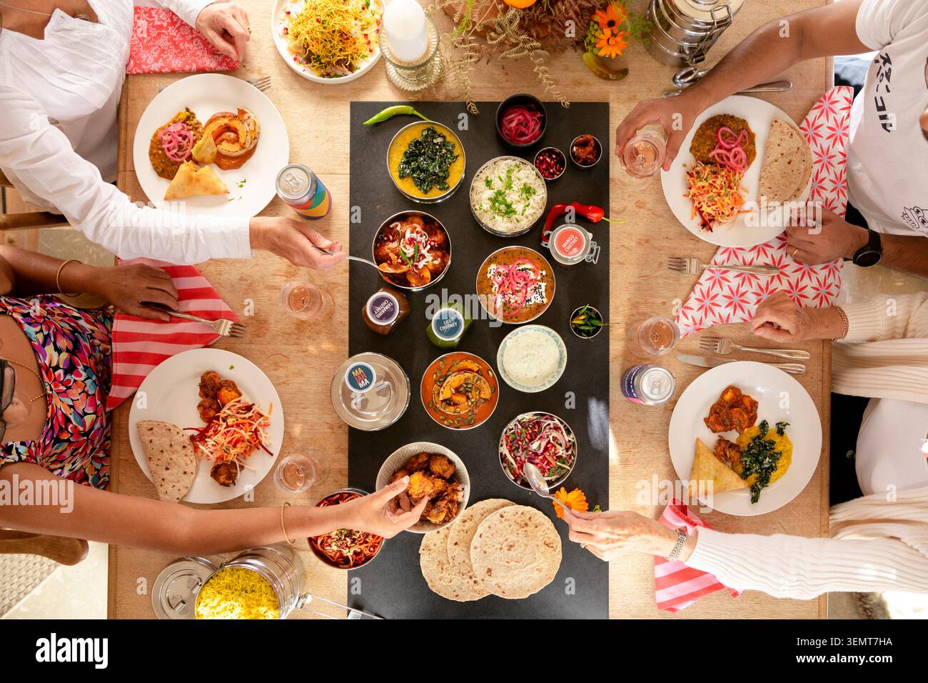 Incontro per una vivace festa indiana con la famiglia e gli amici al Sunny Table Foto Stock