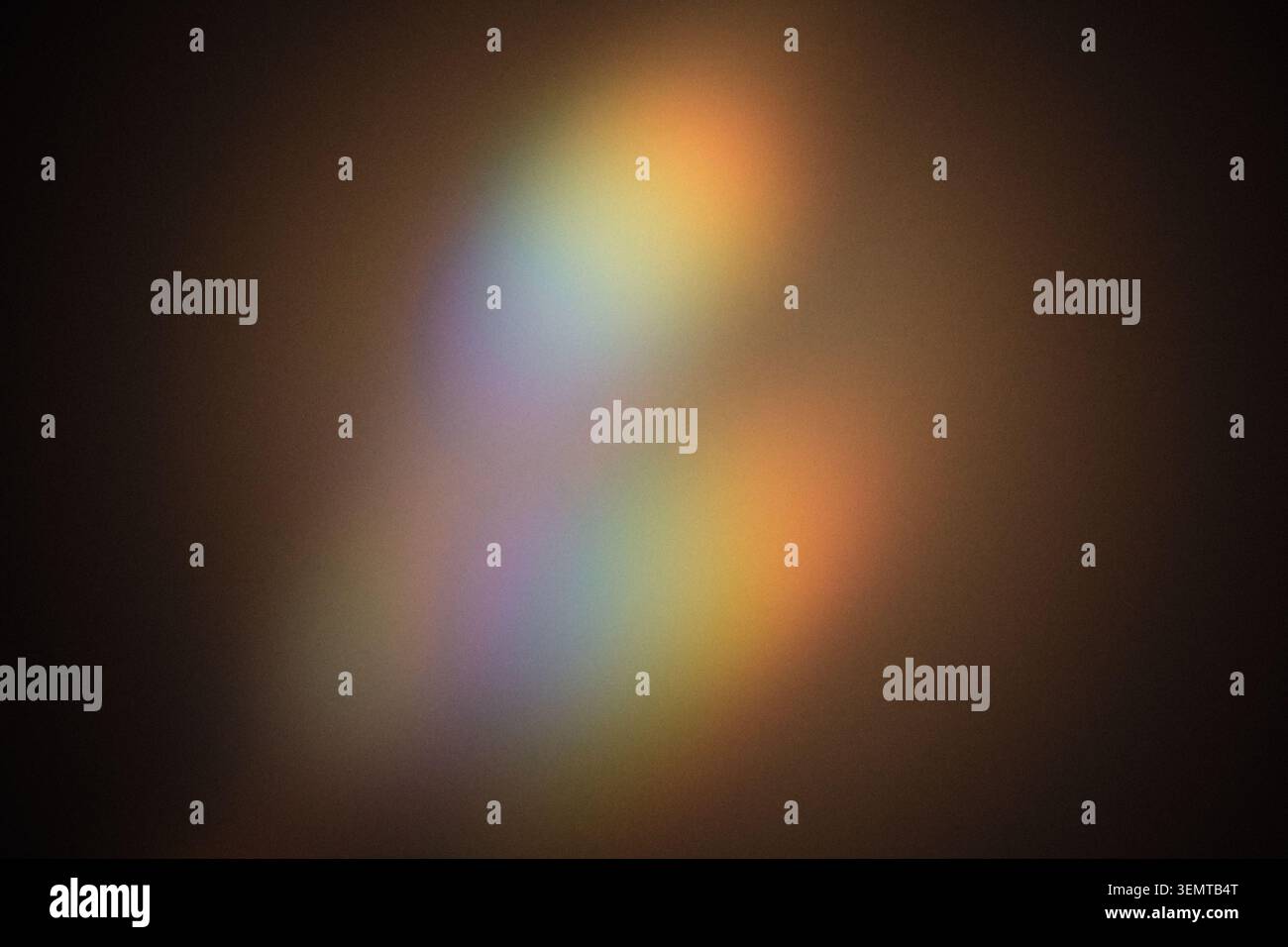 Uno spettro luminoso dai colori tenui rifrangente su sfondo scuro, creando effetti bokeh Foto Stock
