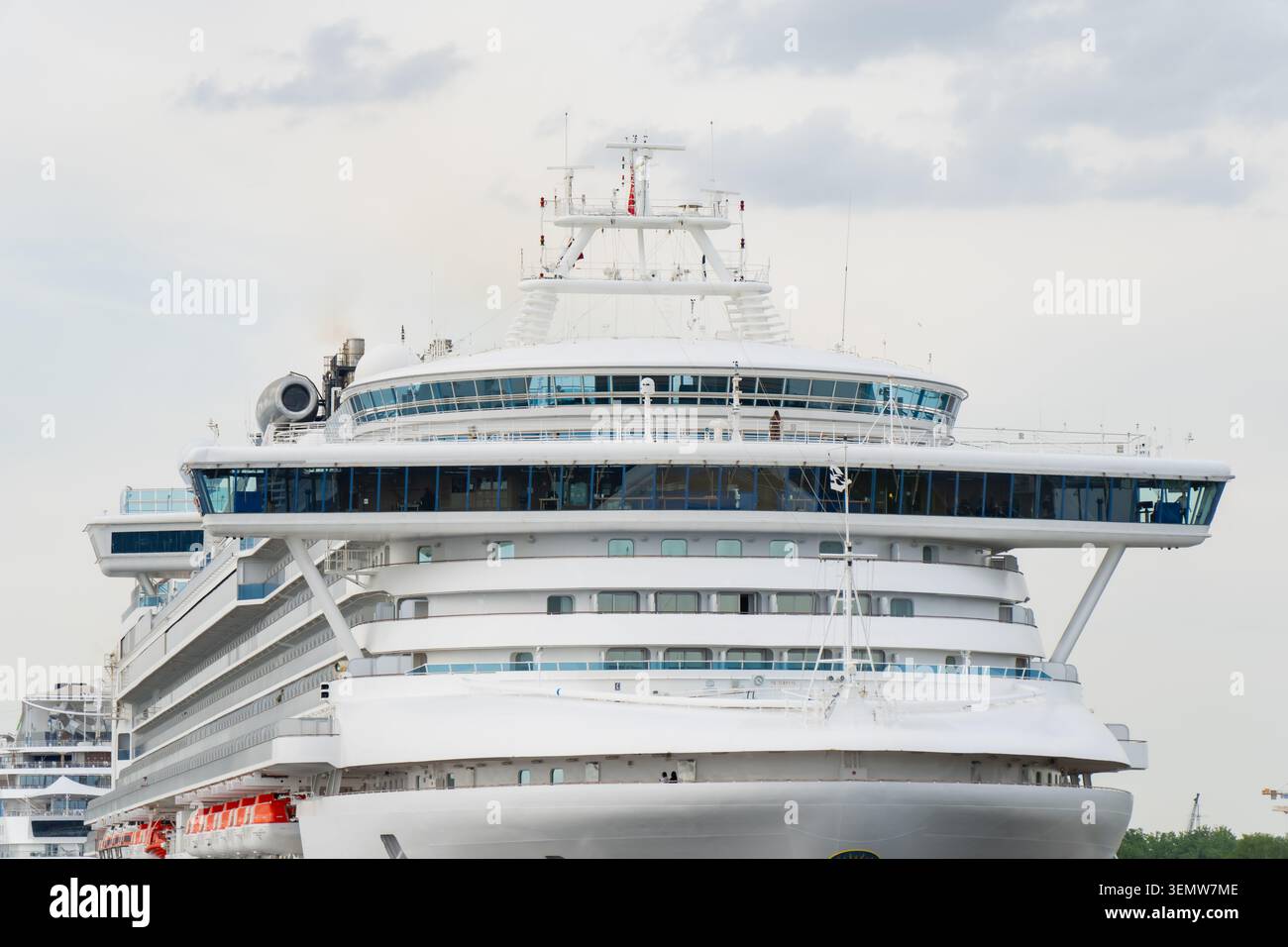 Moderno transatlantico bianco per passeggeri che domina la sovrastruttura del ponte con diversi ponti di osservazione e finestre di navigazione chiuse in vetro Foto Stock