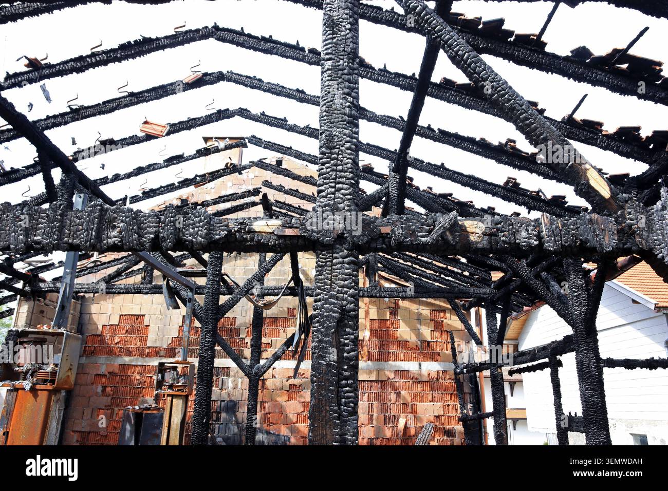 Dopo un incendio di una casa, tutto quello che rimane è nero, travi carbonizzate Foto Stock
