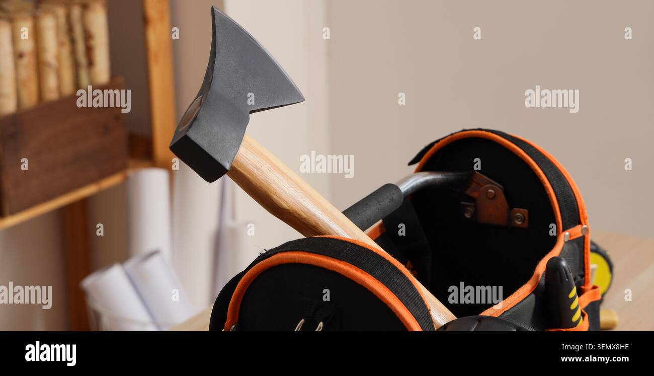 Manico in legno, ascia e borsa portautensili su tavolo in legno, attrezzature per la casa e l'edilizia Foto Stock