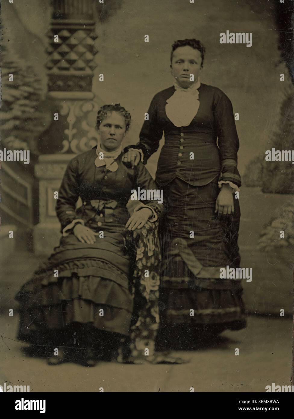Una fotografia a tinta raffigurante due donne posate in un ambiente di studio, risalente approssimativamente agli anni '1870 e all'inizio degli anni '1880 Foto Stock