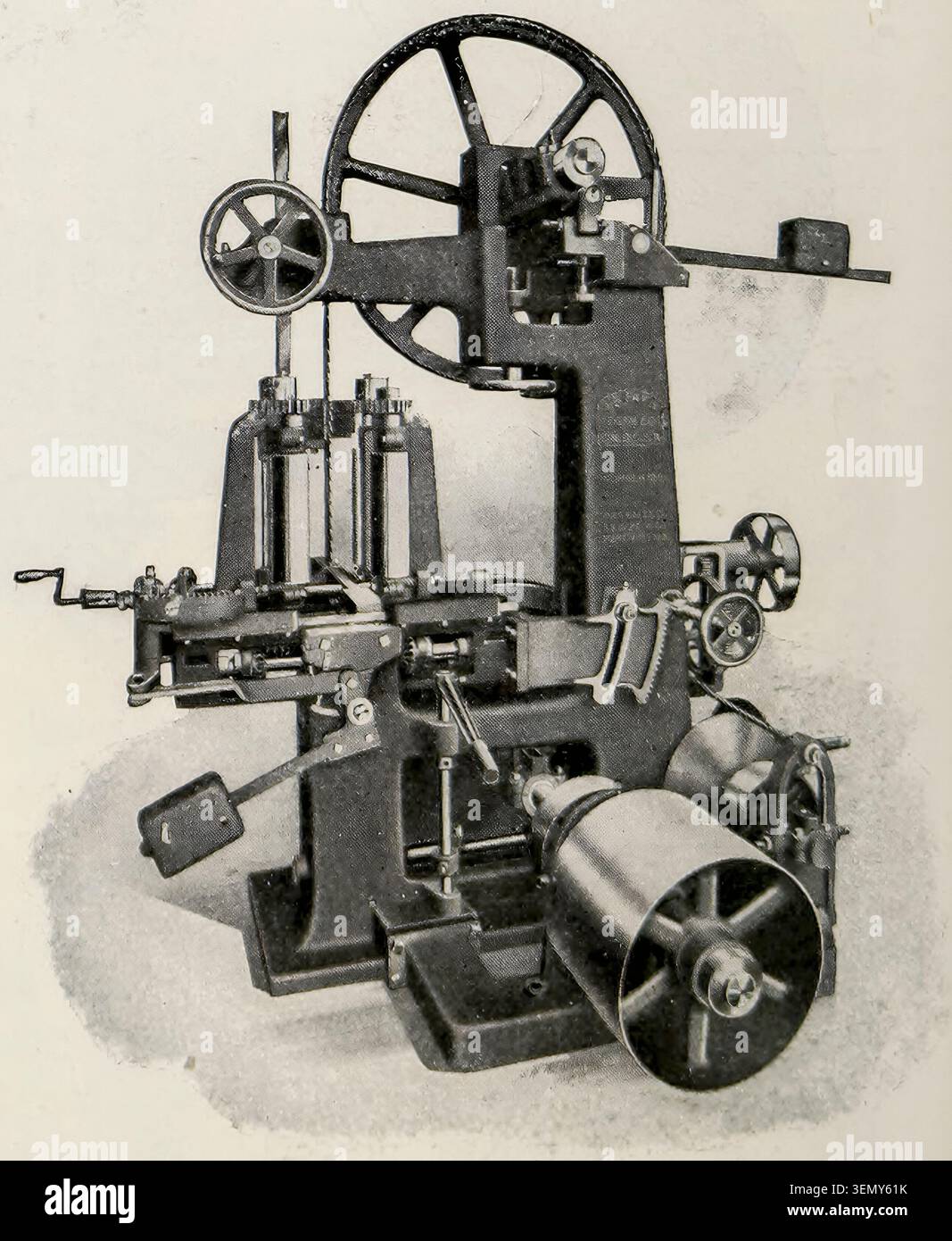 Macchina per la produzione industriale con componenti meccanici complessi, ingranaggi e un grande volano, che rappresenta la tecnologia e l'ingegneria storica, in un'illustrazione monocromatica. Dalla rivista Engineering dedicata al progresso industriale volume XXXIII aprile - settembre 1907 The Engineering Magazine Co. Foto Stock