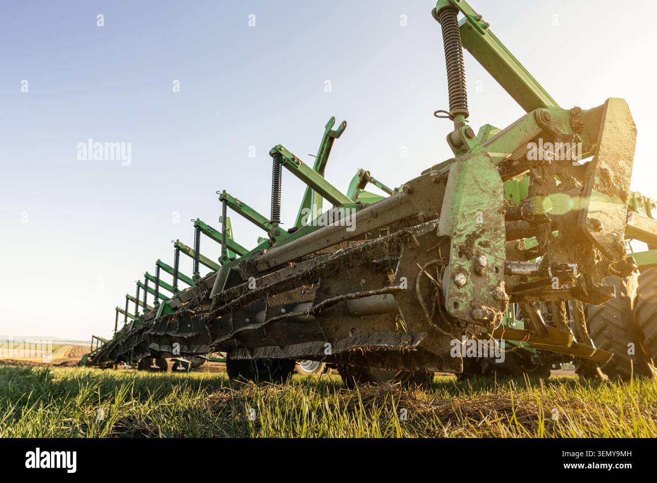 Vista ravvicinata di un coltivatore su terreni agricoli. Componenti delle macchine agricole preparazione del suolo coltivazione del terreno agricoltura e lavoro stagionale sul campo. Foto Stock