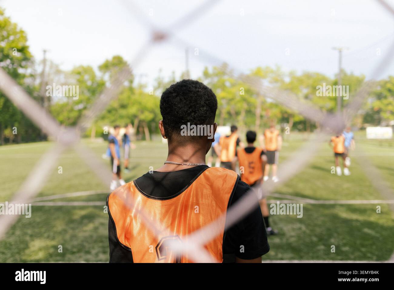 Giocatore di calcio africano in piedi vicino alla rete Goal sul campo da calcio all'aperto Foto Stock