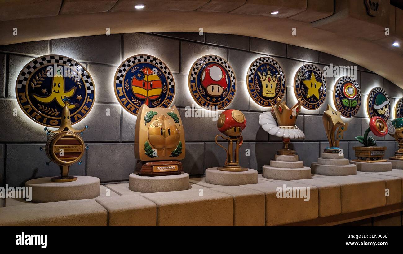 Trofei Super Mario e emblemi illuminati dei personaggi di Mario Kart in mostra agli Universal Studios di Osaka, Giappone. Foto Stock