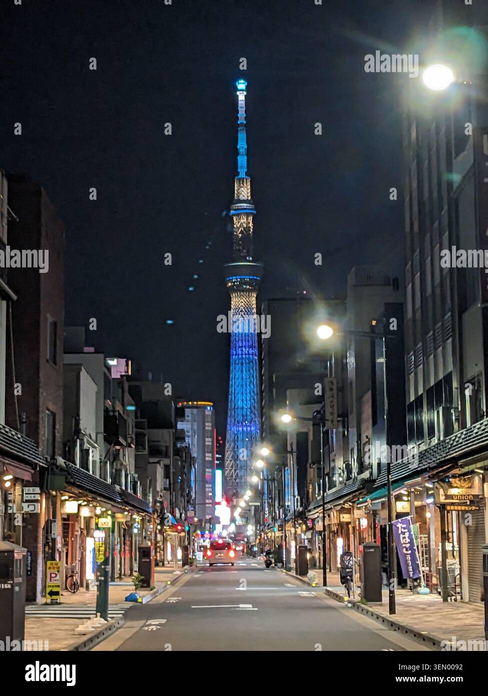 Iconico grattacielo di Taipei 101 illuminato in blu di notte, visto da una stretta strada illuminata a Taipei, Taiwan Foto Stock
