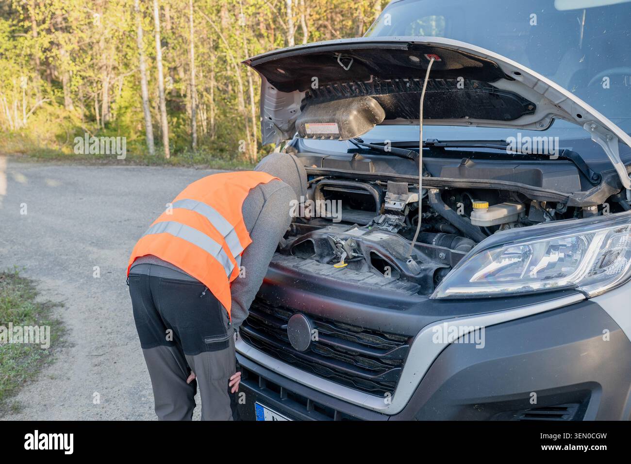 operatore dell'assistenza stradale che ispeziona il vano motore del furgone di consegna rotto Foto Stock