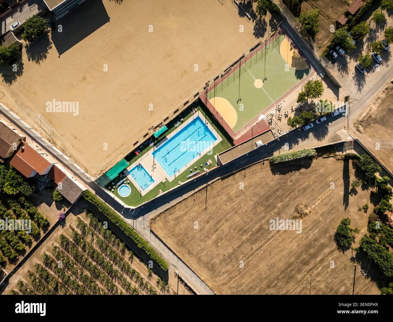 Vista aerea di un complesso sportivo con piscina, campi sportivi e campi circostanti. Foto Stock