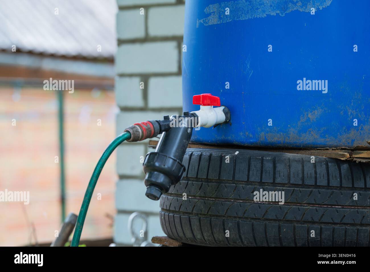 Cilindro di raccolta dell'acqua piovana con sistema di filtraggio per irrigazione Foto Stock