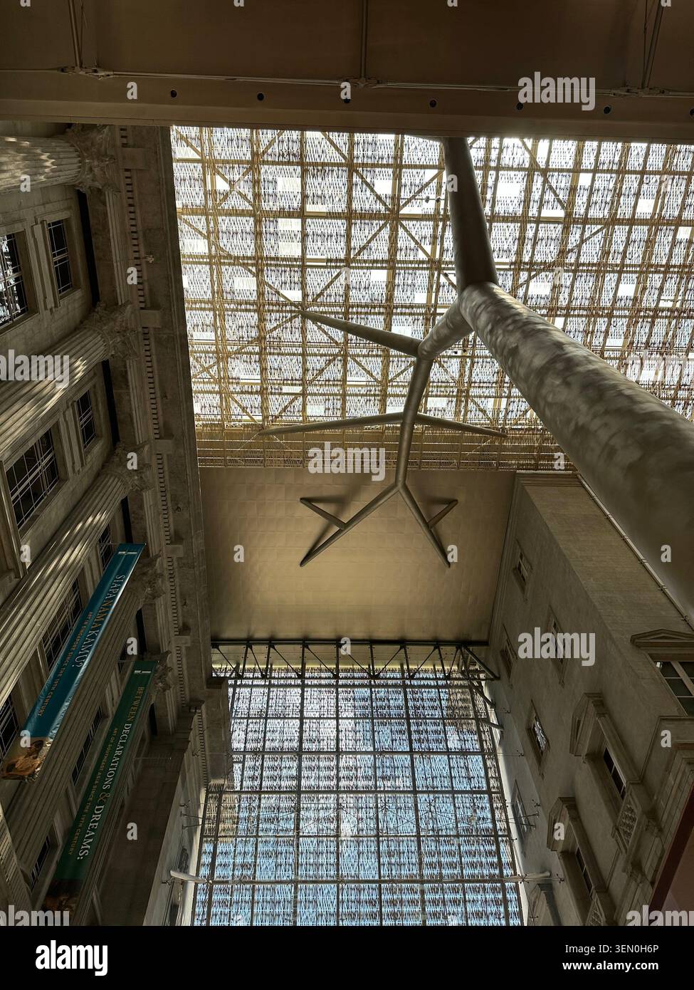 Guarda verso l'alto, molto in alto: una colonna d'acciaio a forma di stella sostiene un vasto atrio con tetto di vetro alla National Gallery di Singapore - Immagine stock catturata con smartphone