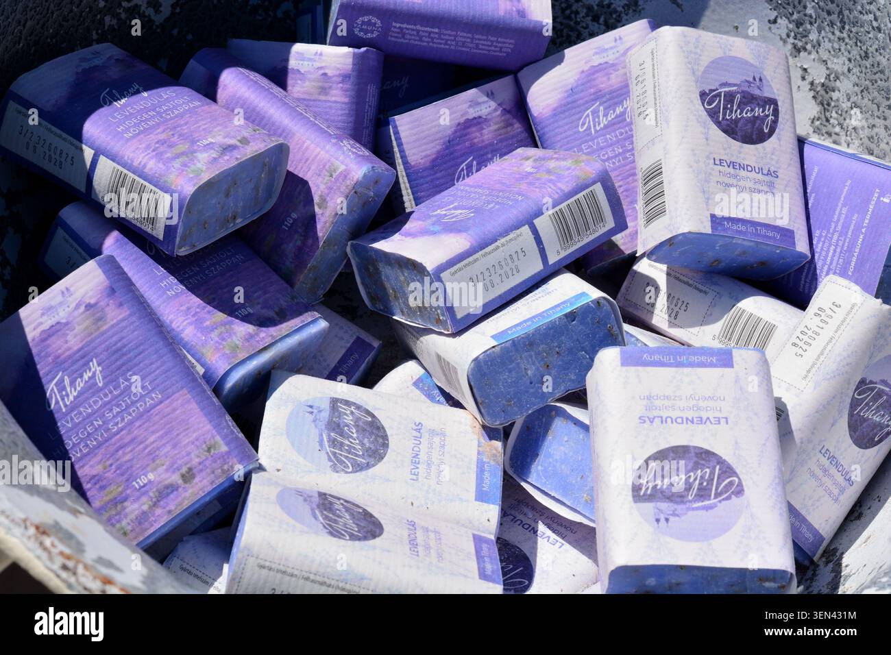 Una pila di confezioni di sapone fatte a mano a tema lavanda esposte insieme, mettendo in evidenza prodotti naturali per la cura della pelle ispirati ai campi aromatici di lavanda e al bo Foto Stock