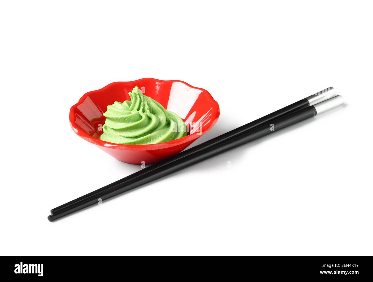 Pasta di wasabi verde in ciotola rossa con bacchette nere, cucina asiatica e condimento sushi Foto Stock