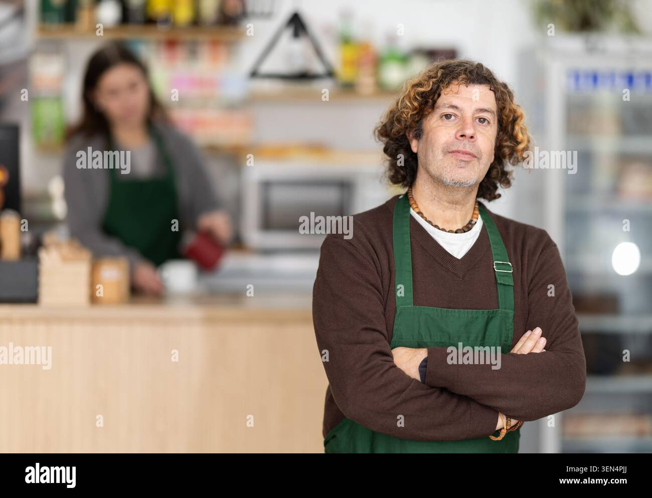Giorni lavorativi nella panetteria, l'uomo lavoratore della mini panetteria si prepara a incontrare i visitatori del caffè. Foto Stock
