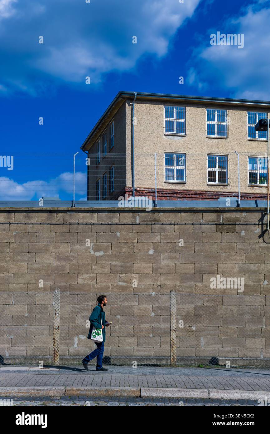 Una passeggiata pedonale lungo il muro esterno del Memoriale di Berlino-Hohenschönhausen (Gedenkstätte Berlin Hohenschönhausen), noto anche come prigione della Stasi. Foto Stock