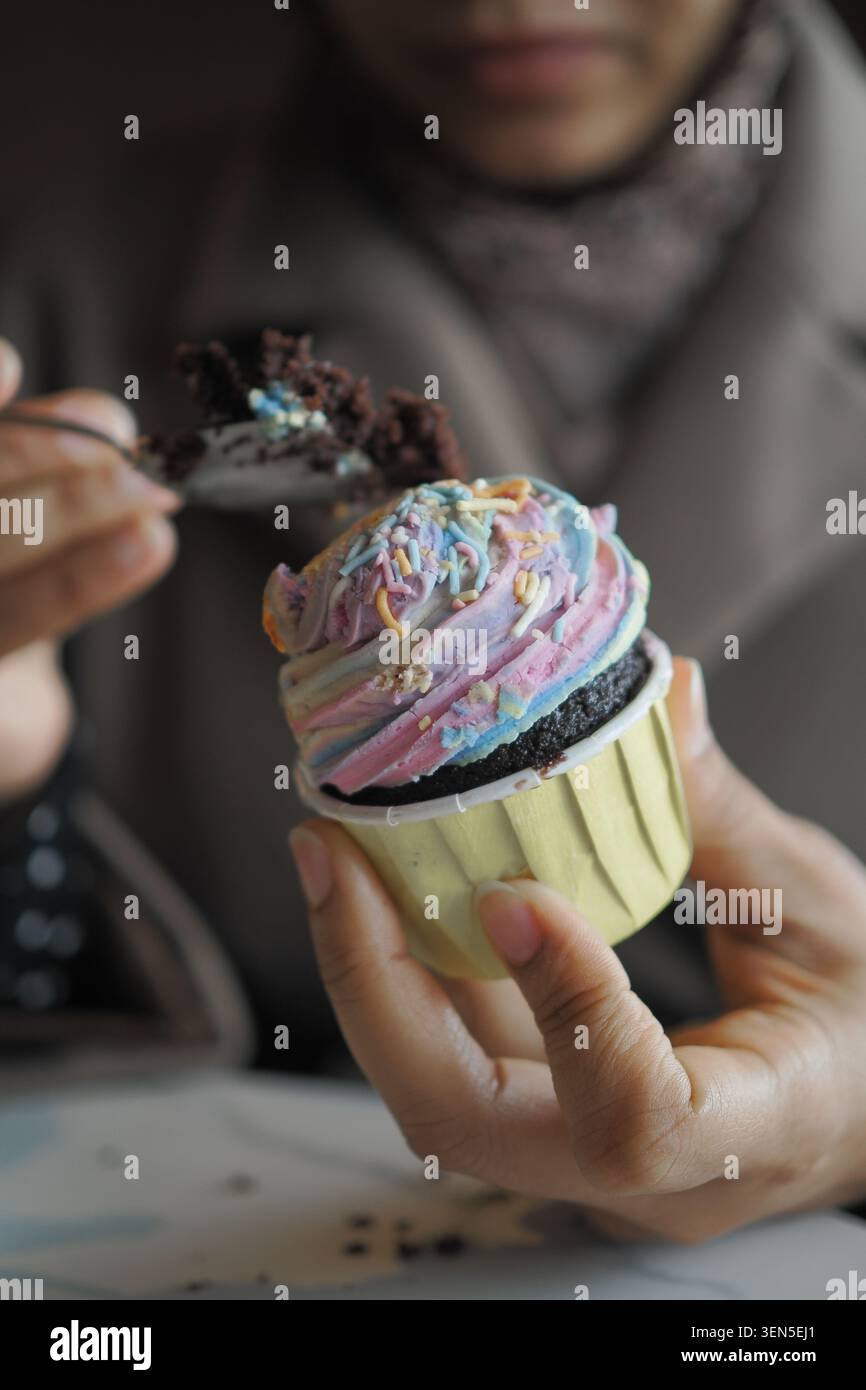 La persona ama il cupcake nel caffè durante il pomeriggio Foto Stock
