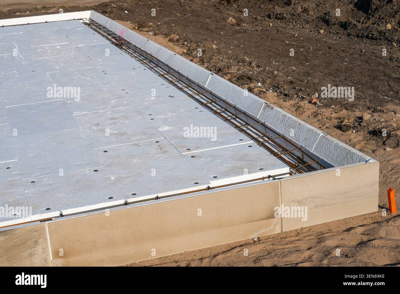Primo piano della trave isolata del bordo della fondazione della soletta con rinforzo per armature pronto per il versamento di calcestruzzo e la costruzione di abitazioni Foto Stock
