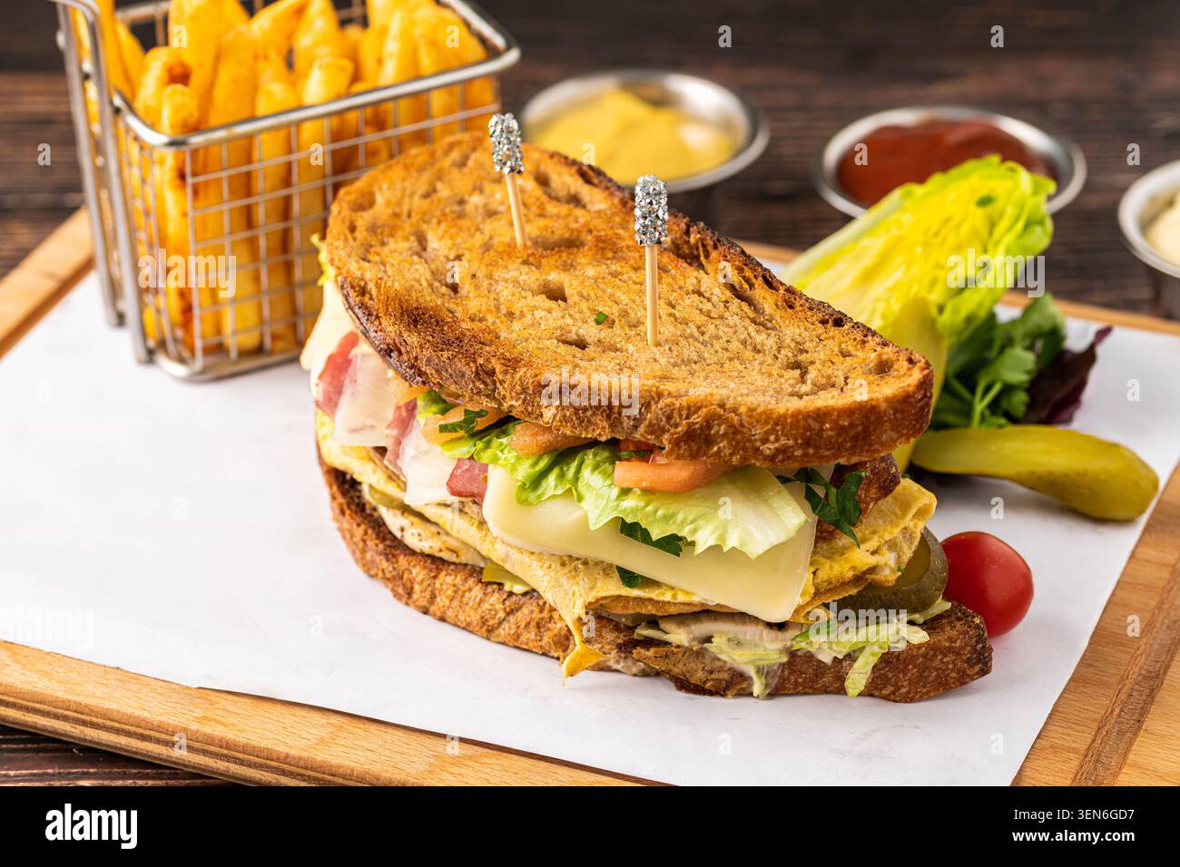 Delizioso club sandwich tostato con strati di carne, formaggio e patatine fritte Foto Stock