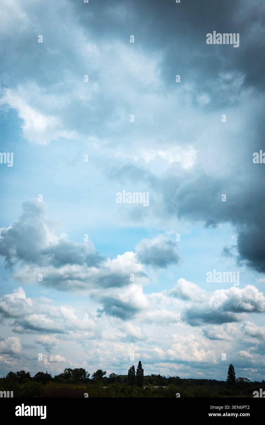 Cielo nuvoloso su un paesaggio verde, con nuvole di tempesta scure e luce blu soffusa dopo la pioggia Foto Stock