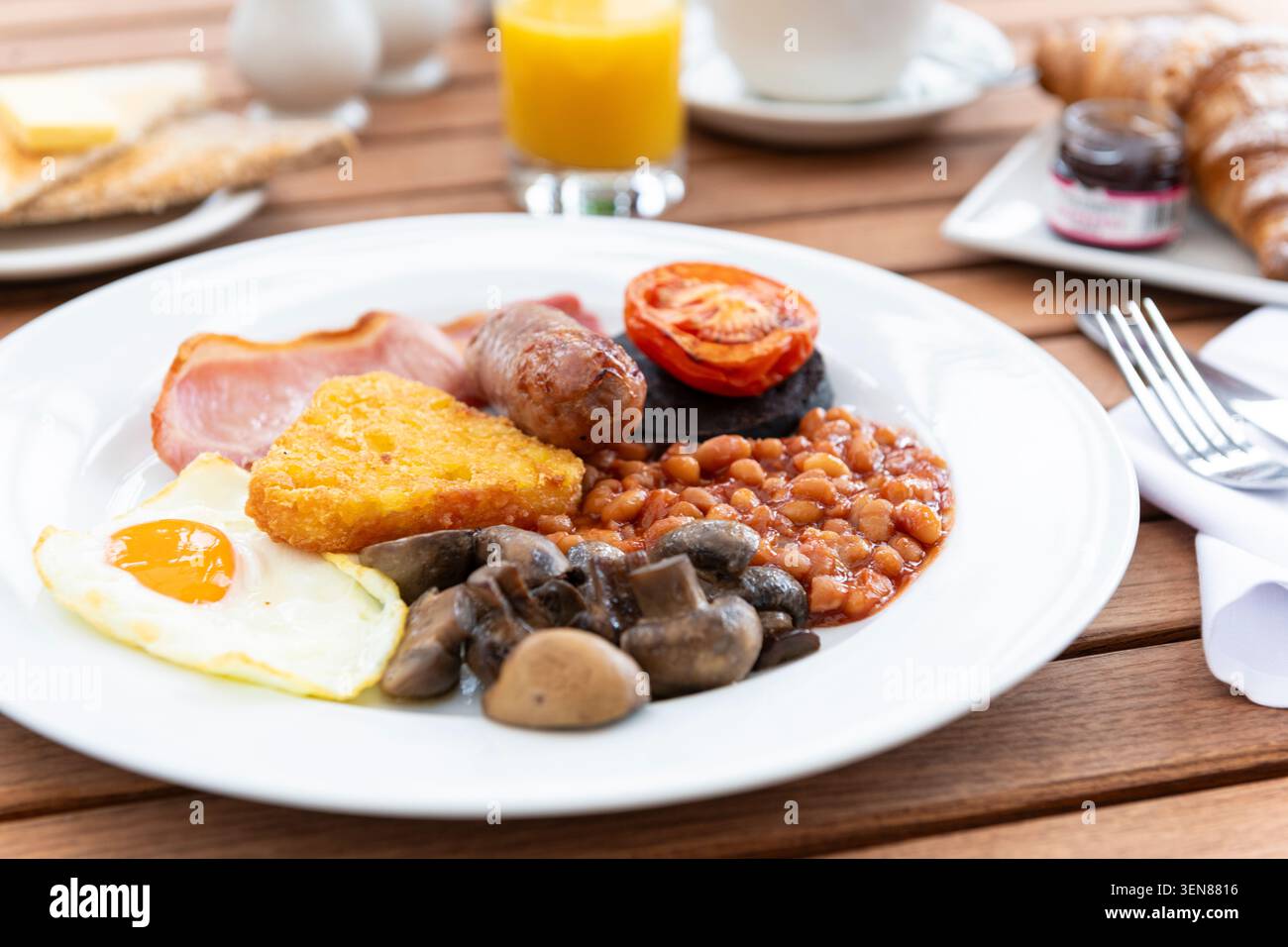 Deliziosa colazione a buffet con uova, salsicce, pomodori e fagioli la mattina soleggiata Foto Stock