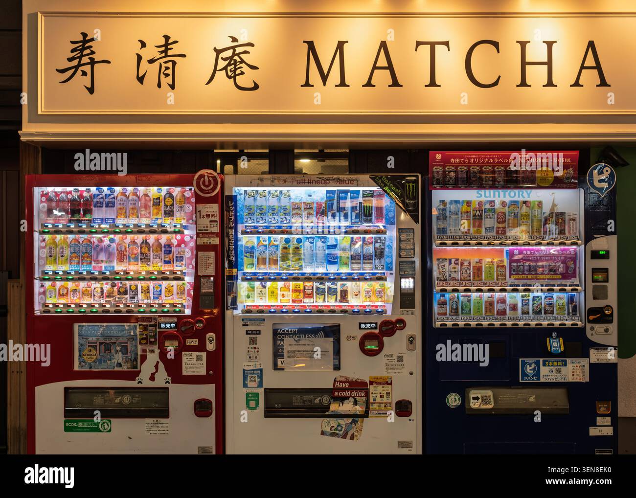 Una fila di moderni distributori automatici che offrono bevande di matcha sotto un luminoso cartello del negozio, Tokyo, Giappone Foto Stock