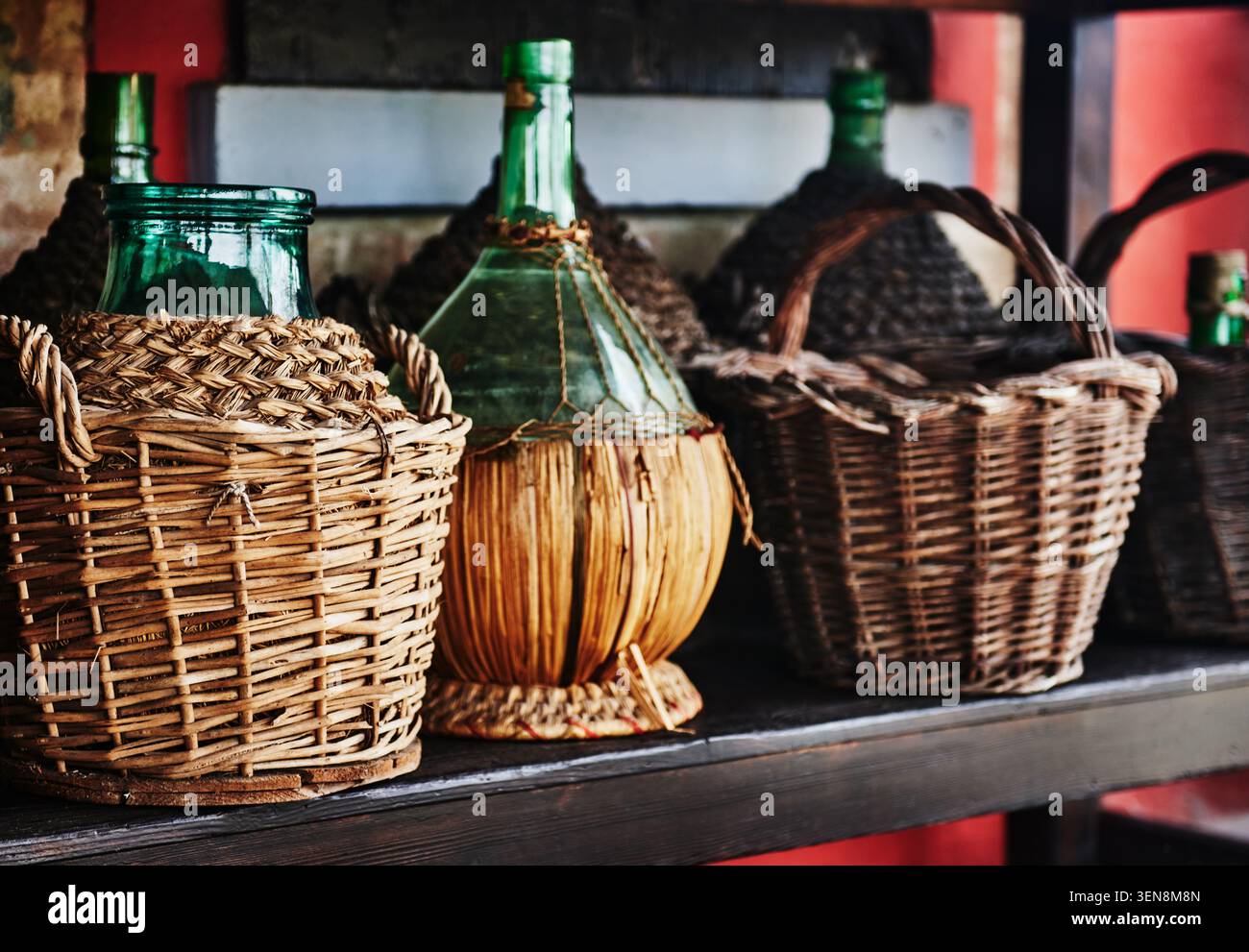 Bottiglia di demijohn francese vintage racchiusa in un cesto di vimini intrecciato a mano. Tradizionalmente utilizzato per il trasporto di vino, liquori o aceto Foto Stock