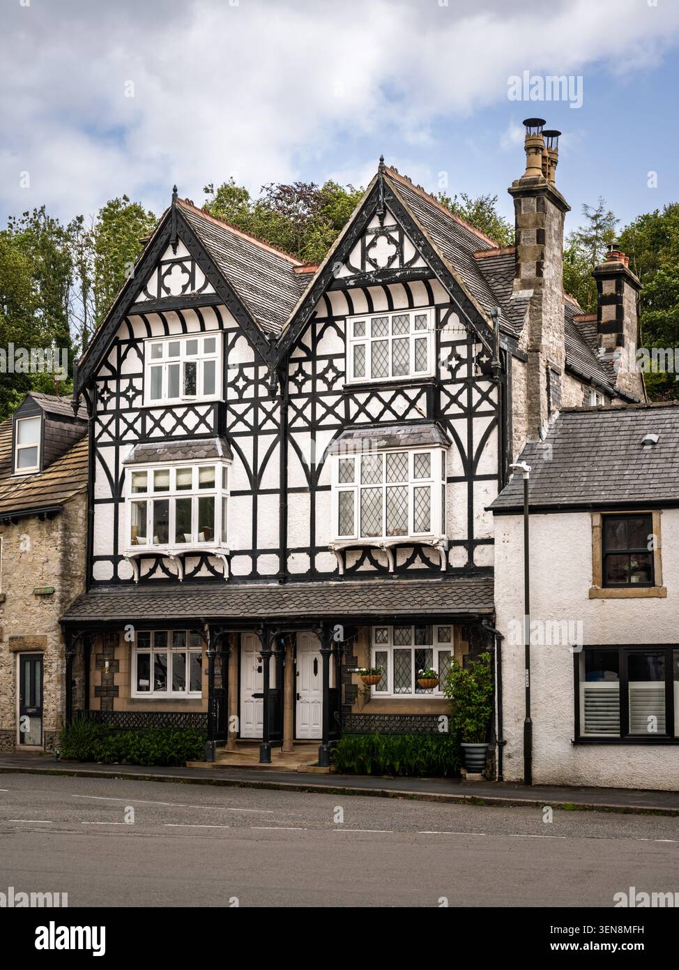 Vista architettonica verticale di una suggestiva struttura in legno a più fronti in bianco e nero, vicino alla piazza del villaggio a Tideswell, Derbyshire Foto Stock