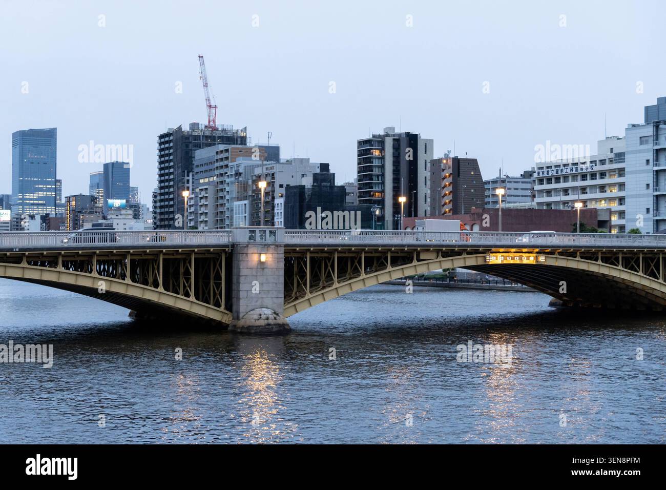 Tokyo, Giappone 2 giugno 2026: Il ponte Eitai attraversa il fiume Sumida a Tokyo. Scena serale con il ponte illuminato e denso sviluppo lungo le rive del fiume *** Die Eitai-Brücke überspannt den Sumida-Fluss a Tokio. Abendstimmung mit beleuchteter Fahrbahn und dichter Uferbebauung Foto Stock