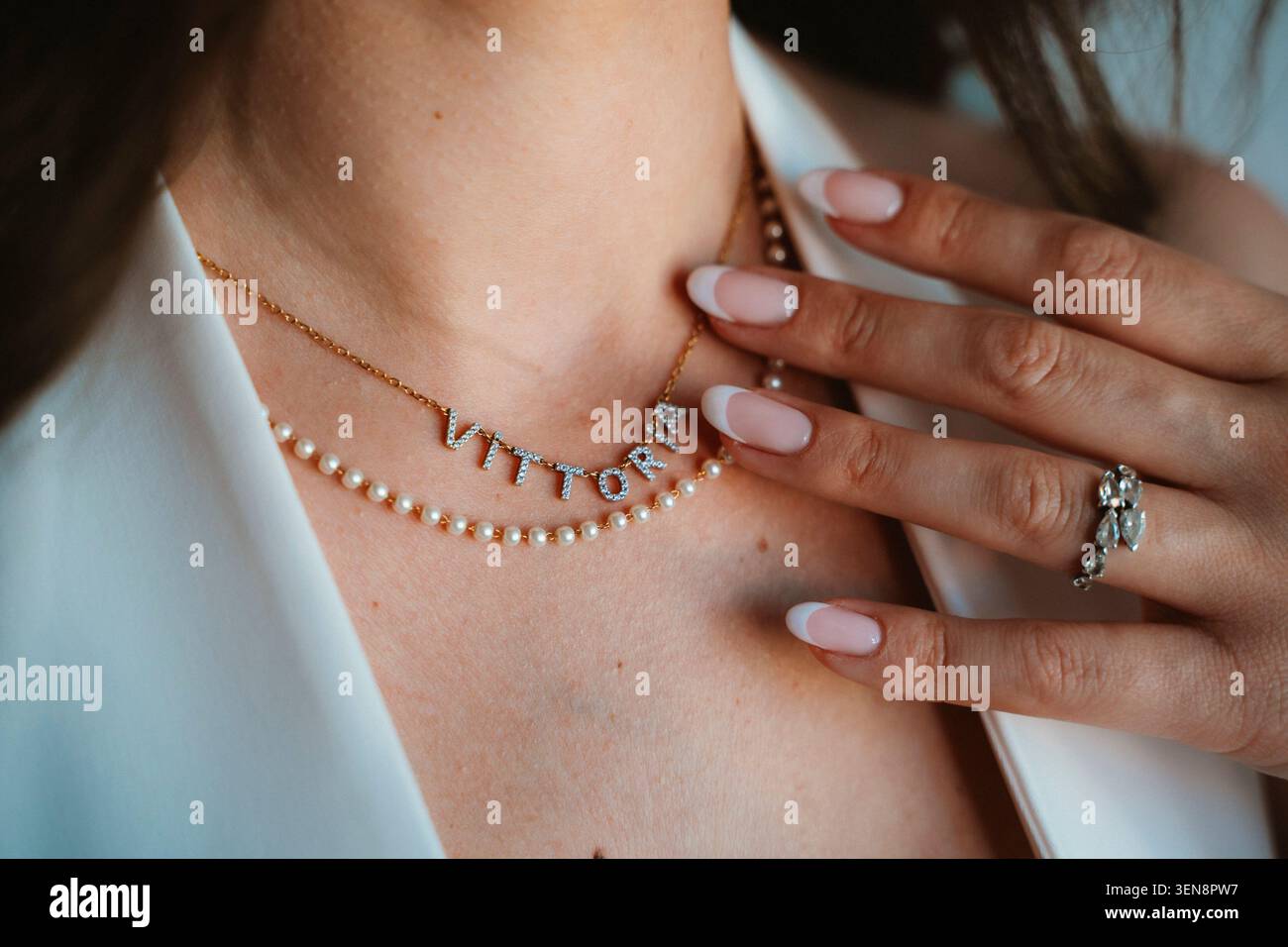 Elegante collana e anello sulla mano di una donna Foto Stock