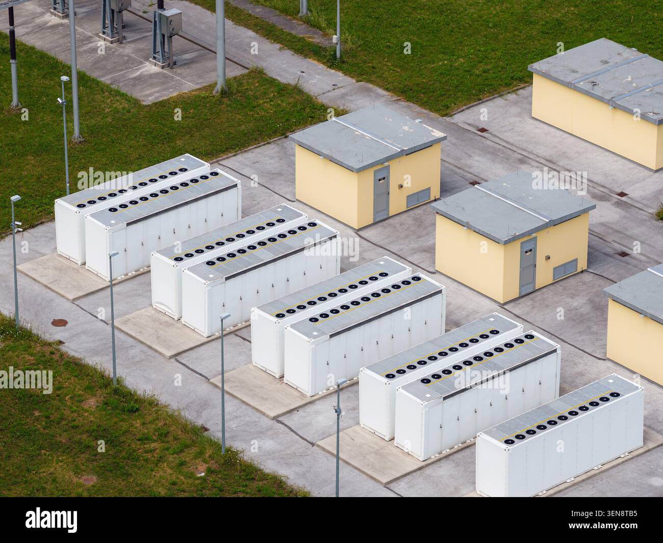 Vista aerea del sistema di accumulo dell'energia della batteria con diverse unità vicino a una sottostazione elettrica e a un'infrastruttura di alimentazione. Foto Stock