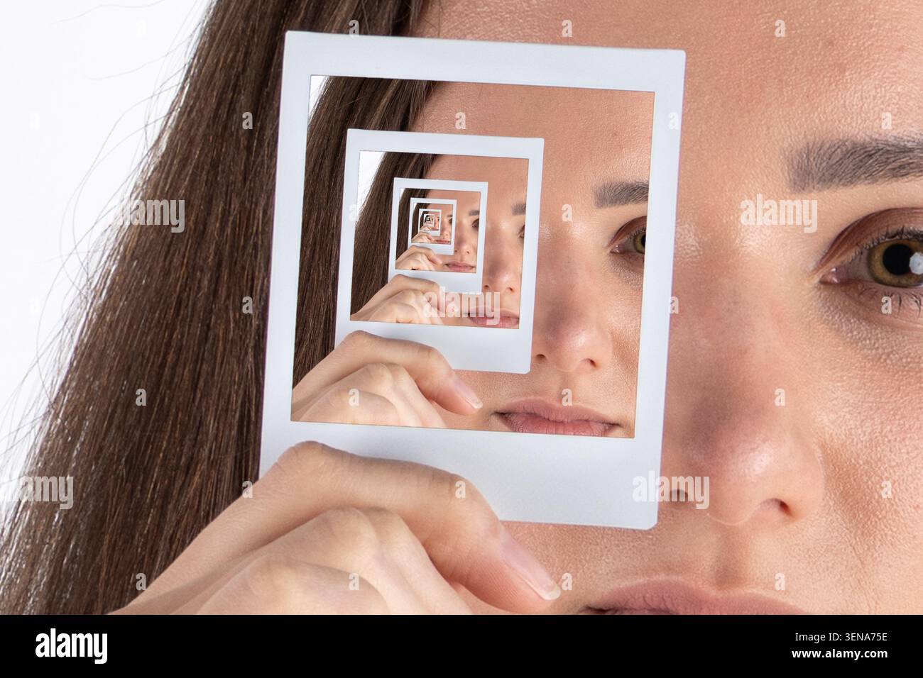 Donna che tiene una cornice quadrata per creare un effetto droste autosimile Foto Stock