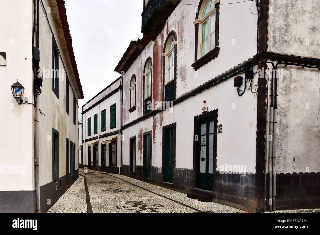 Strada tipica a Povoacao, Sao Miguel, Azzorre. Pareti bianche dipinte con pietra basaltica scura. Tradizionale ciottolato portoghese con decorazioni in pa Foto Stock