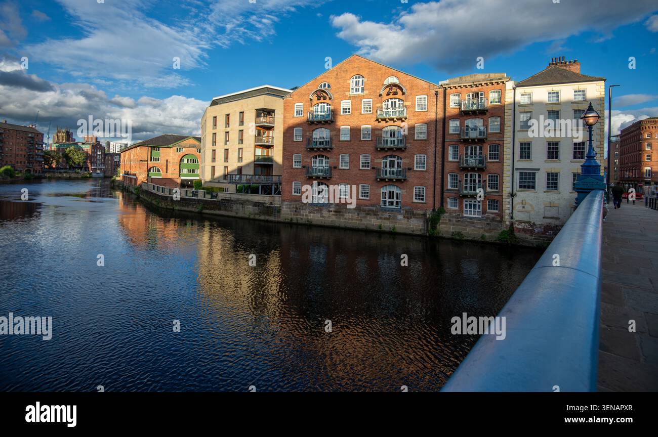 Il fiume Aire e gli edifici rigenerati sono stati convertiti principalmente in appartamenti, visti dal ponte di Leeds Foto Stock
